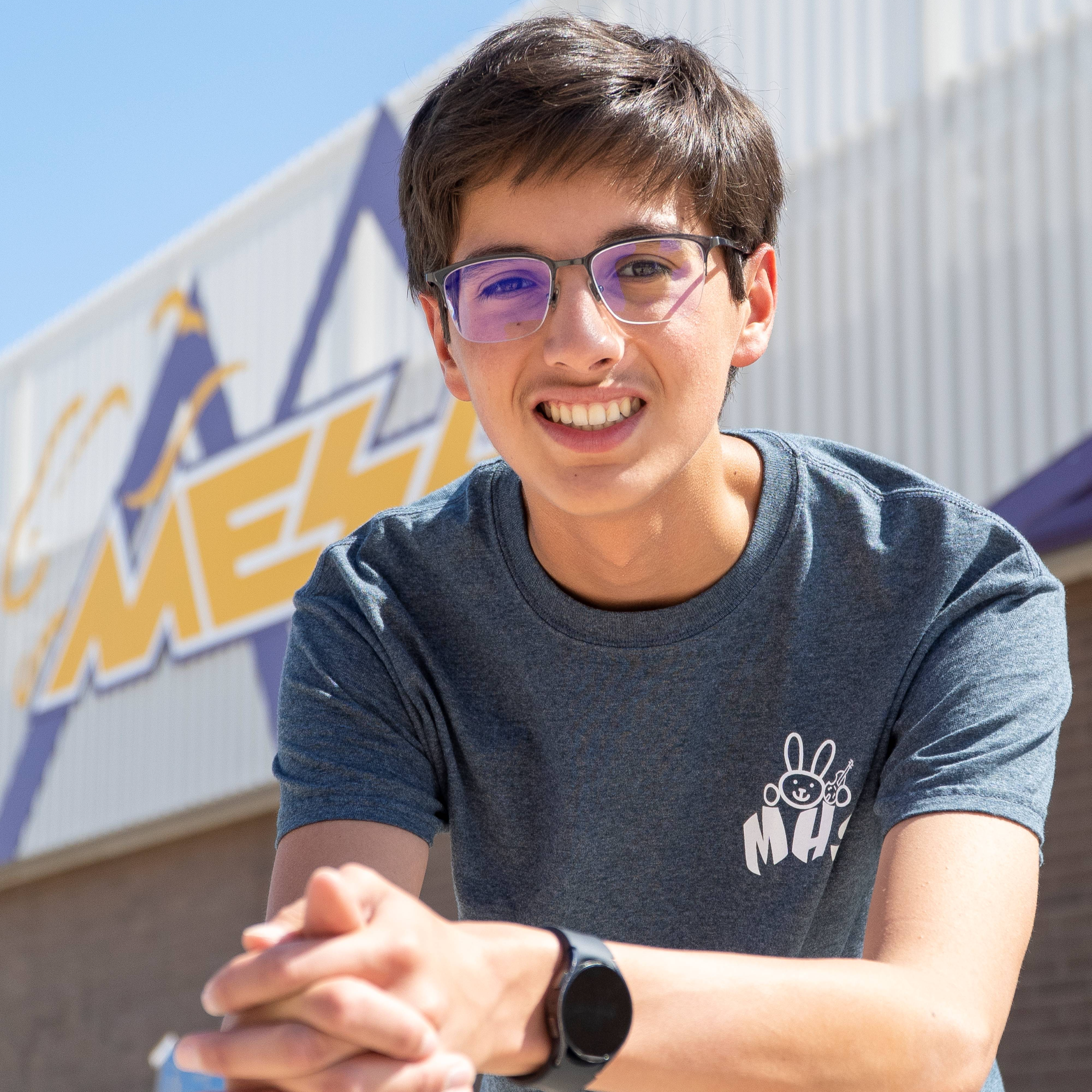 High school male student in front of Mesa High sign