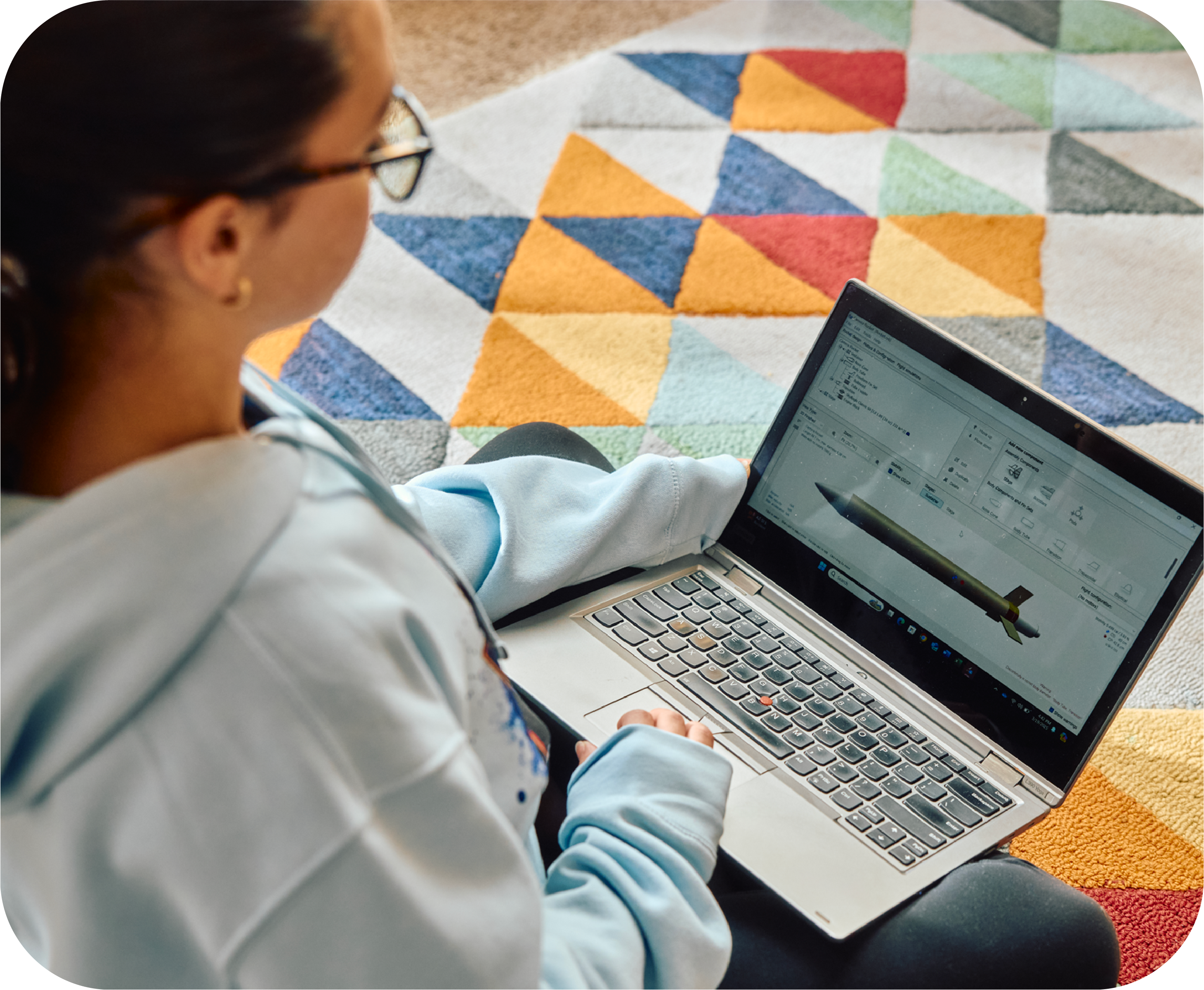 student sitting on floor and working on laptop