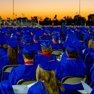Graduates sitting in chairs on football field