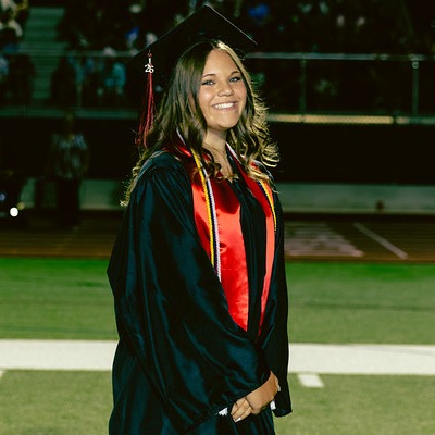 graduate standing on football field