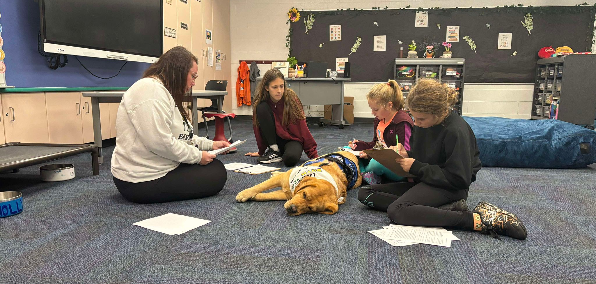 Molly laying with students as they read at Country Oaks Elementary