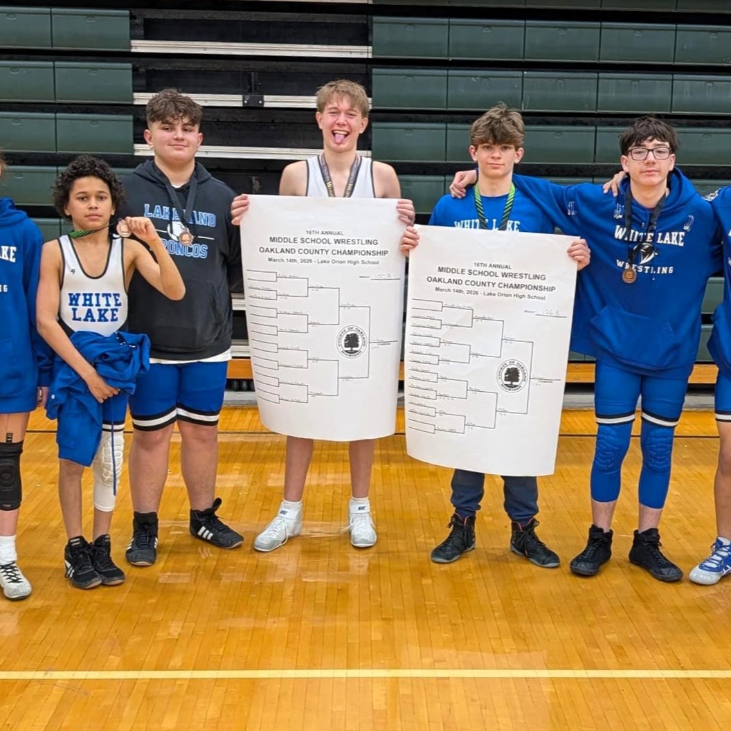 White Lake wrestlers celebrating win on the matt