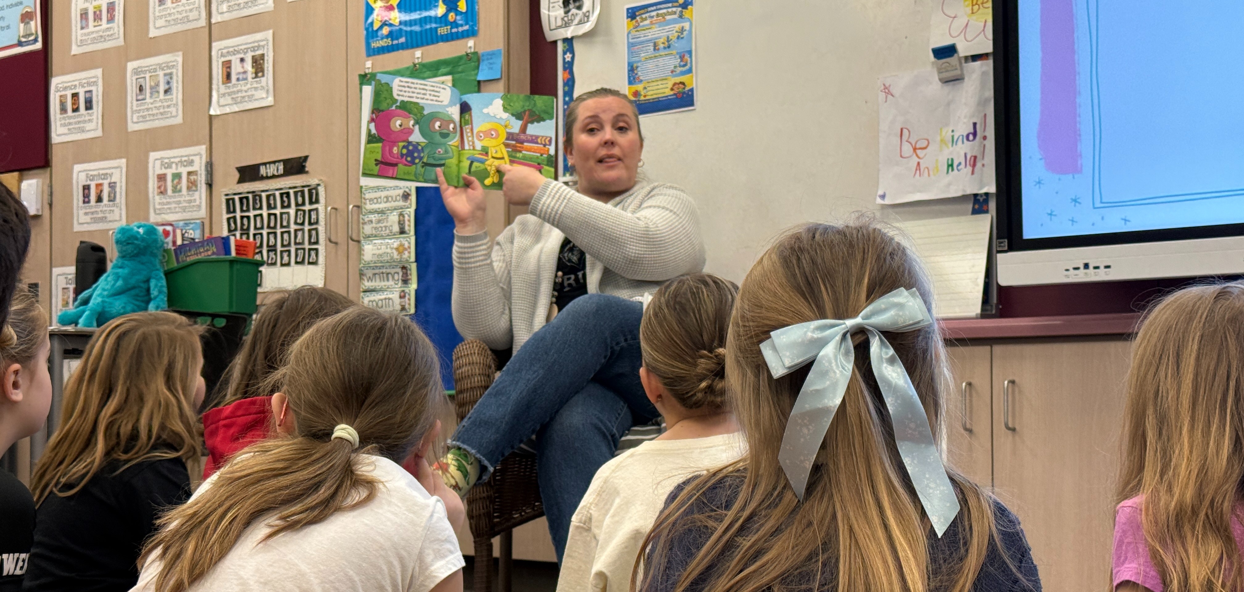 Teacher reading to kids while the sit on the floor