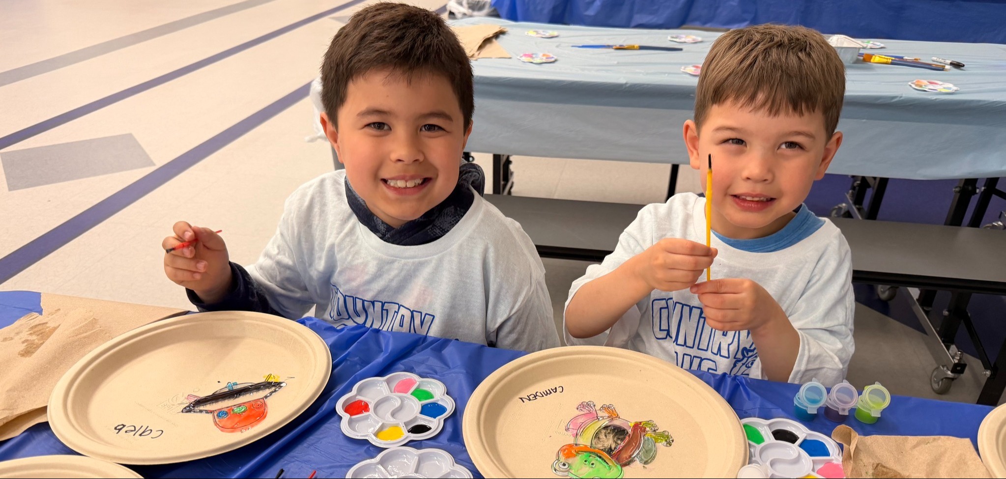 Two elementary students sitting at a table painting