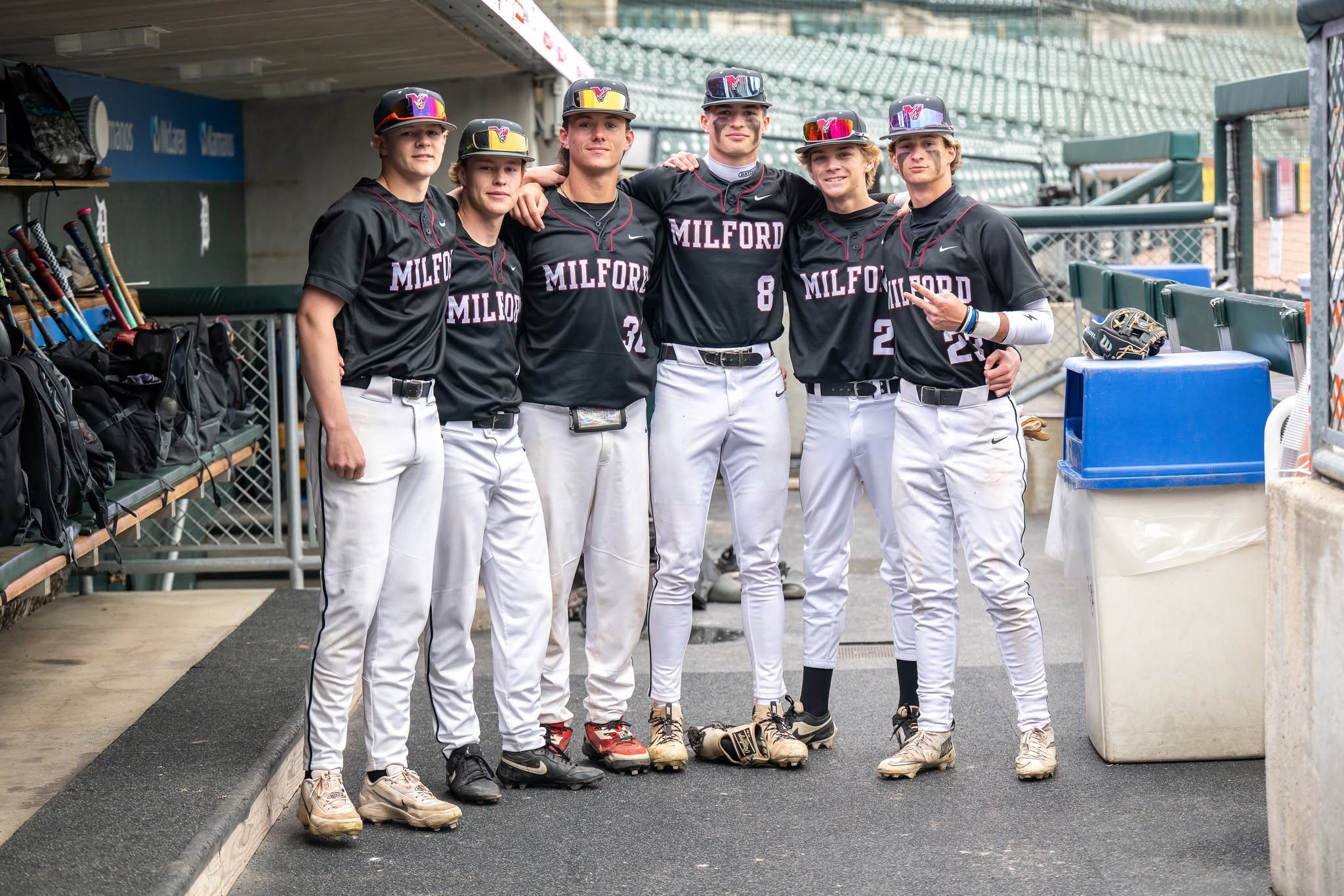 boy baseball players pose for photo in the dugout