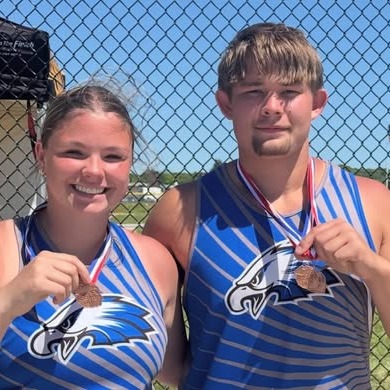 photo of two track members holding medals
