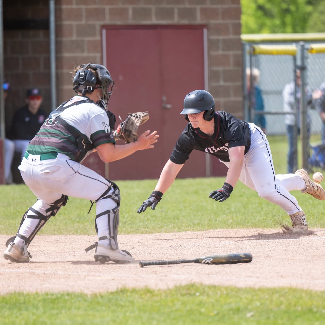 baseball player diving into home as catcher waits for ball