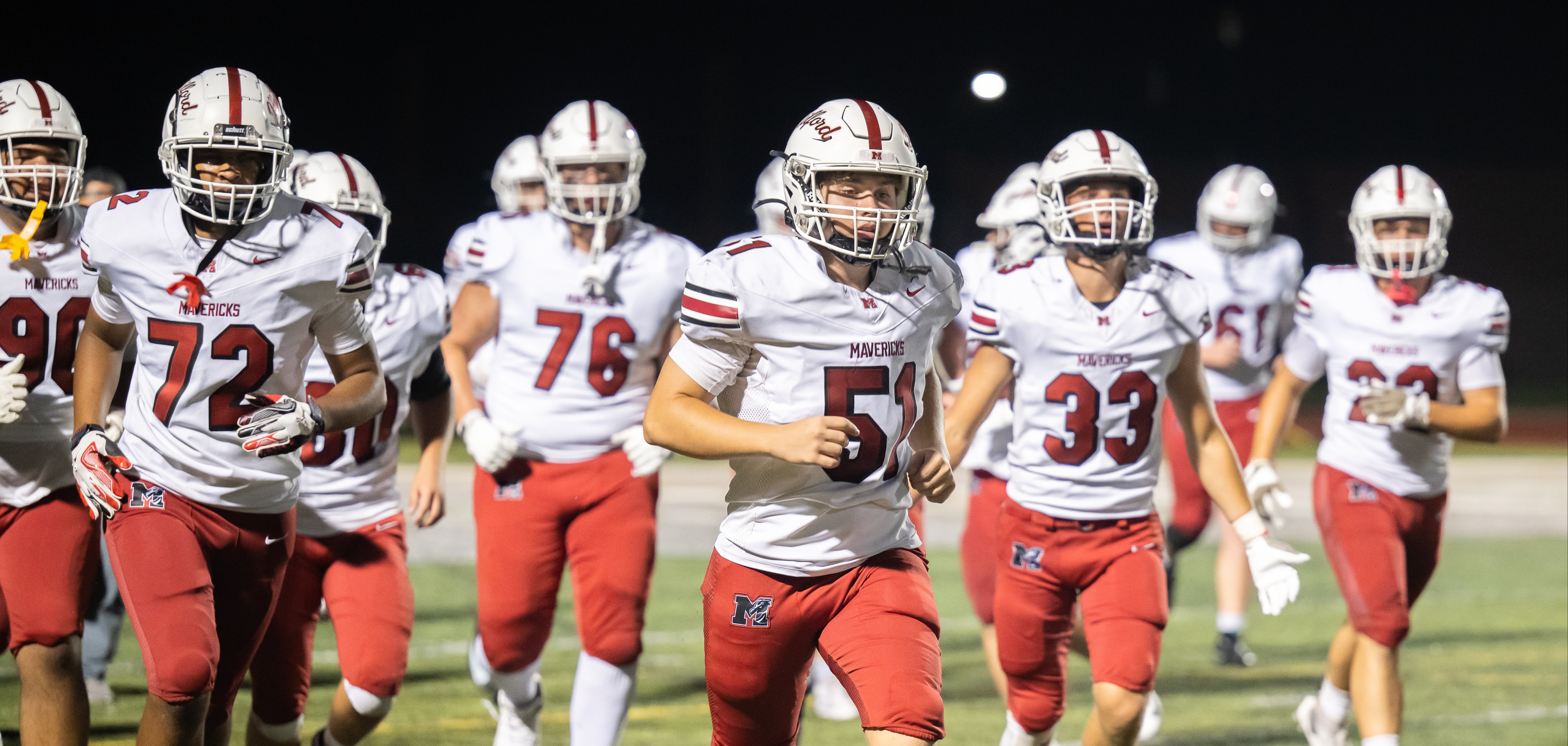 football players jogging onto field during a game 