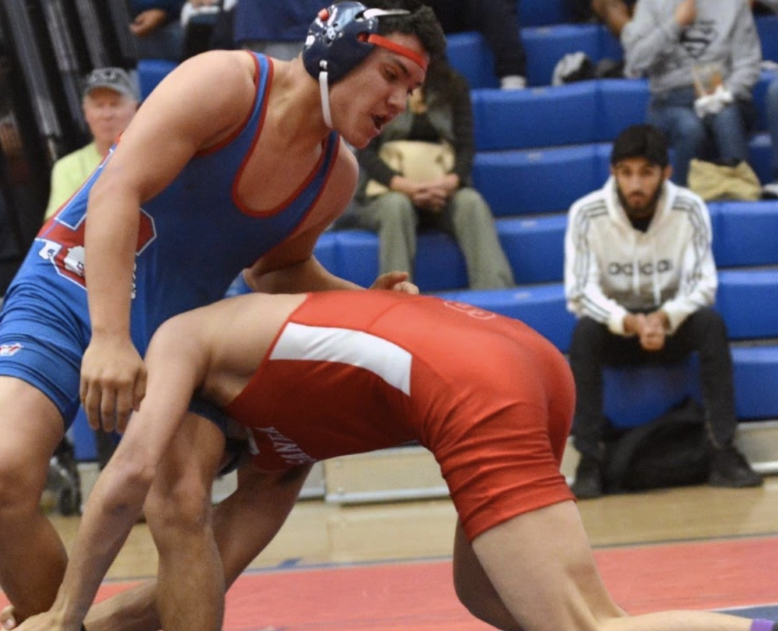 two young man wrestling at gym