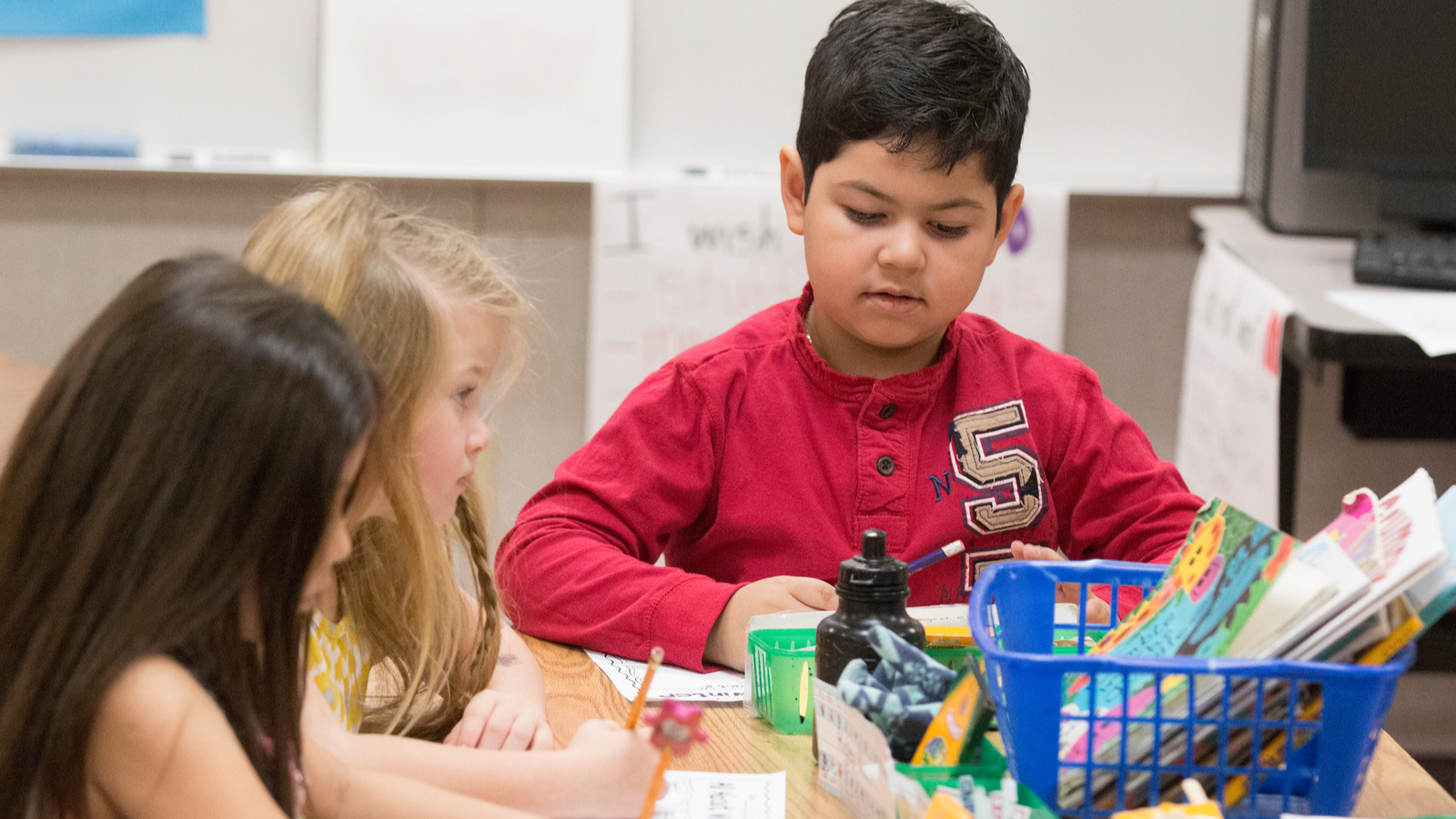 three elementary students working at a table