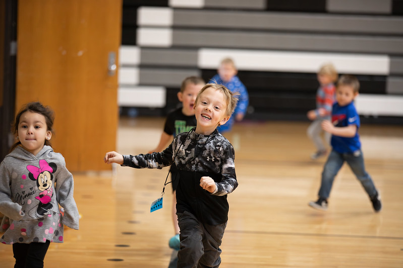 students running in gym towards camera