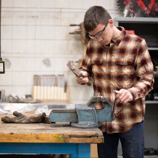 high school student working on a welding project