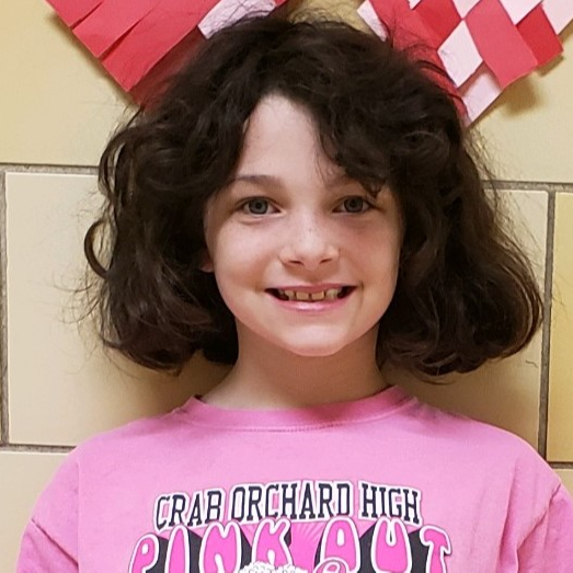 smiling young girl with black hair wearing a  pink "Crab Orchard High Pink Out" t-shirt