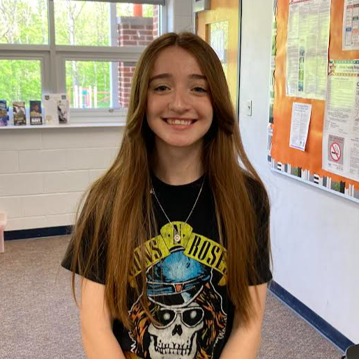High school girl with long brown hear wearing a black t-shirt with a skull