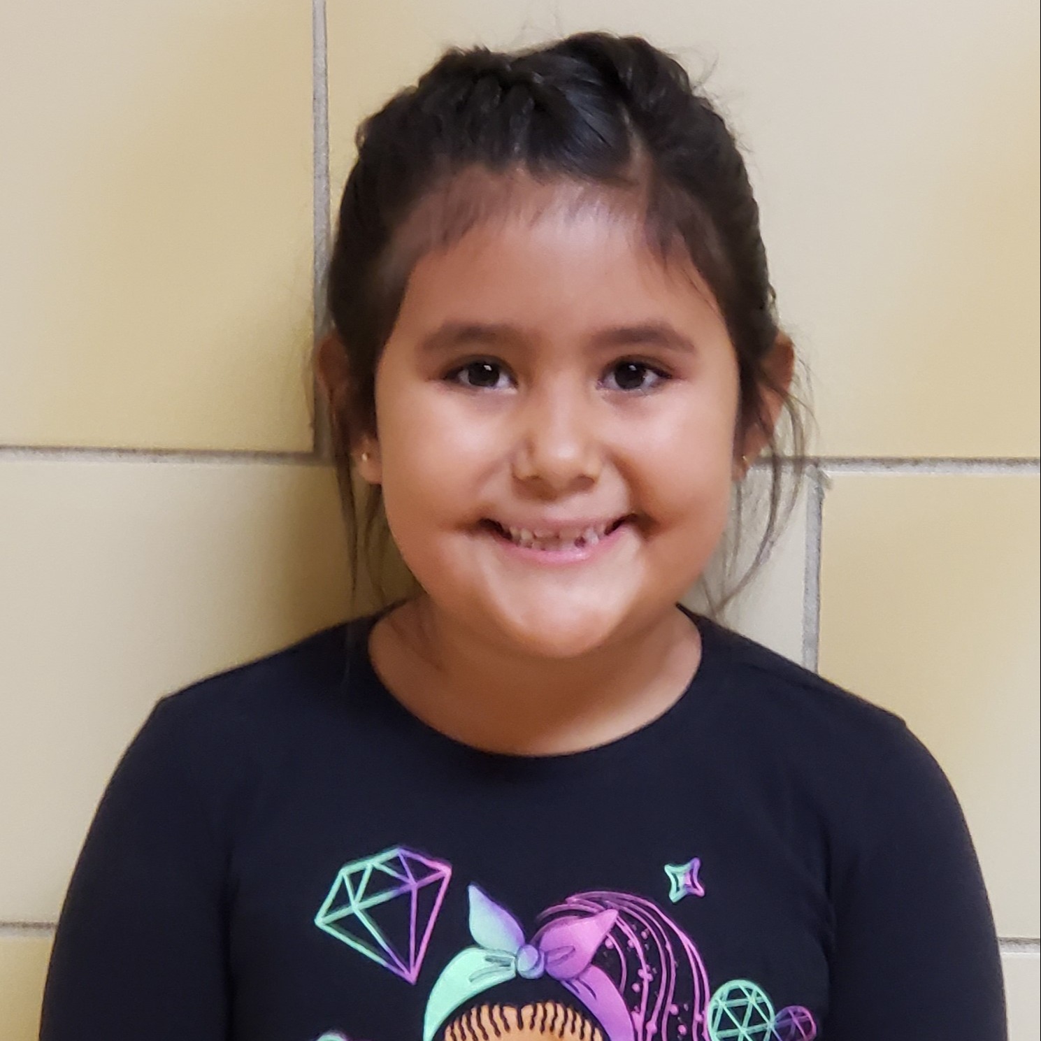 smiling young latina girl with black hair wearing a black shirt