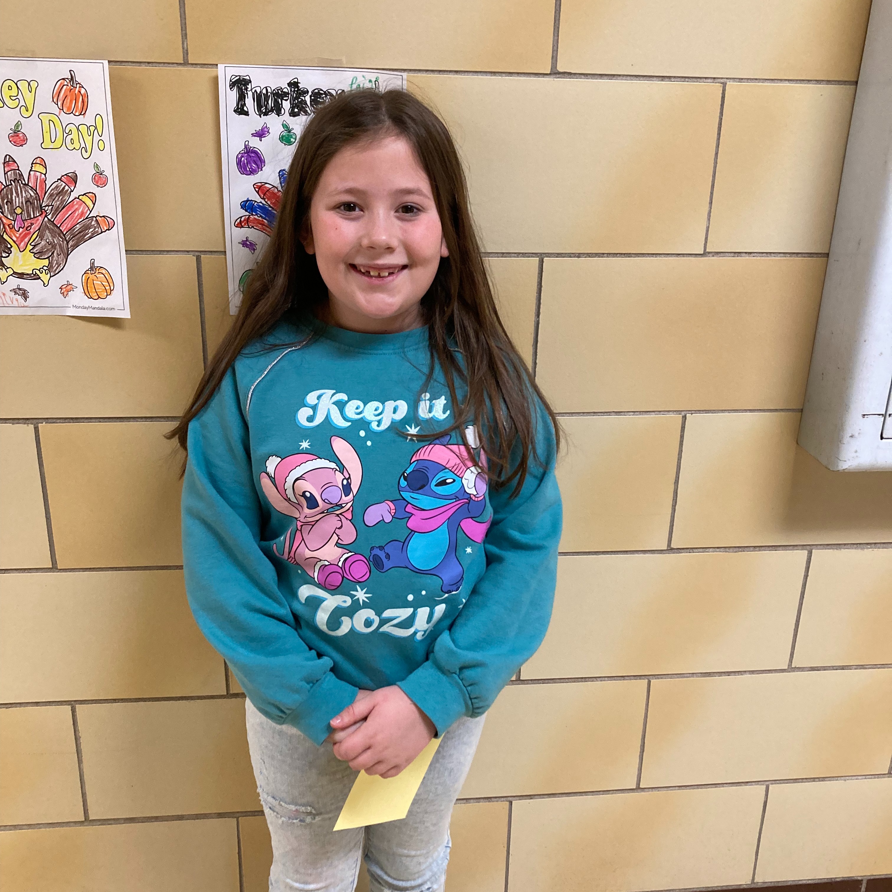 smiling girl with dark hair wearing a turquoise lilo and stitch sweatshirt