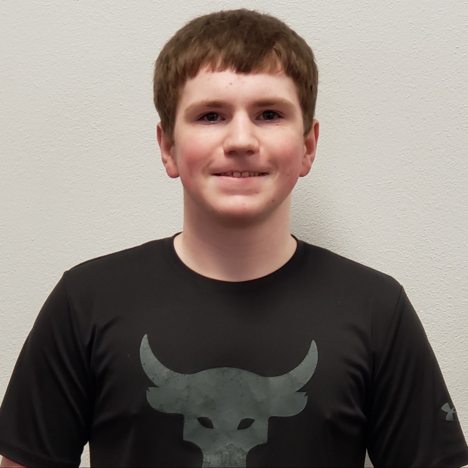 smiling young man with red hair wearing a black t-shirt