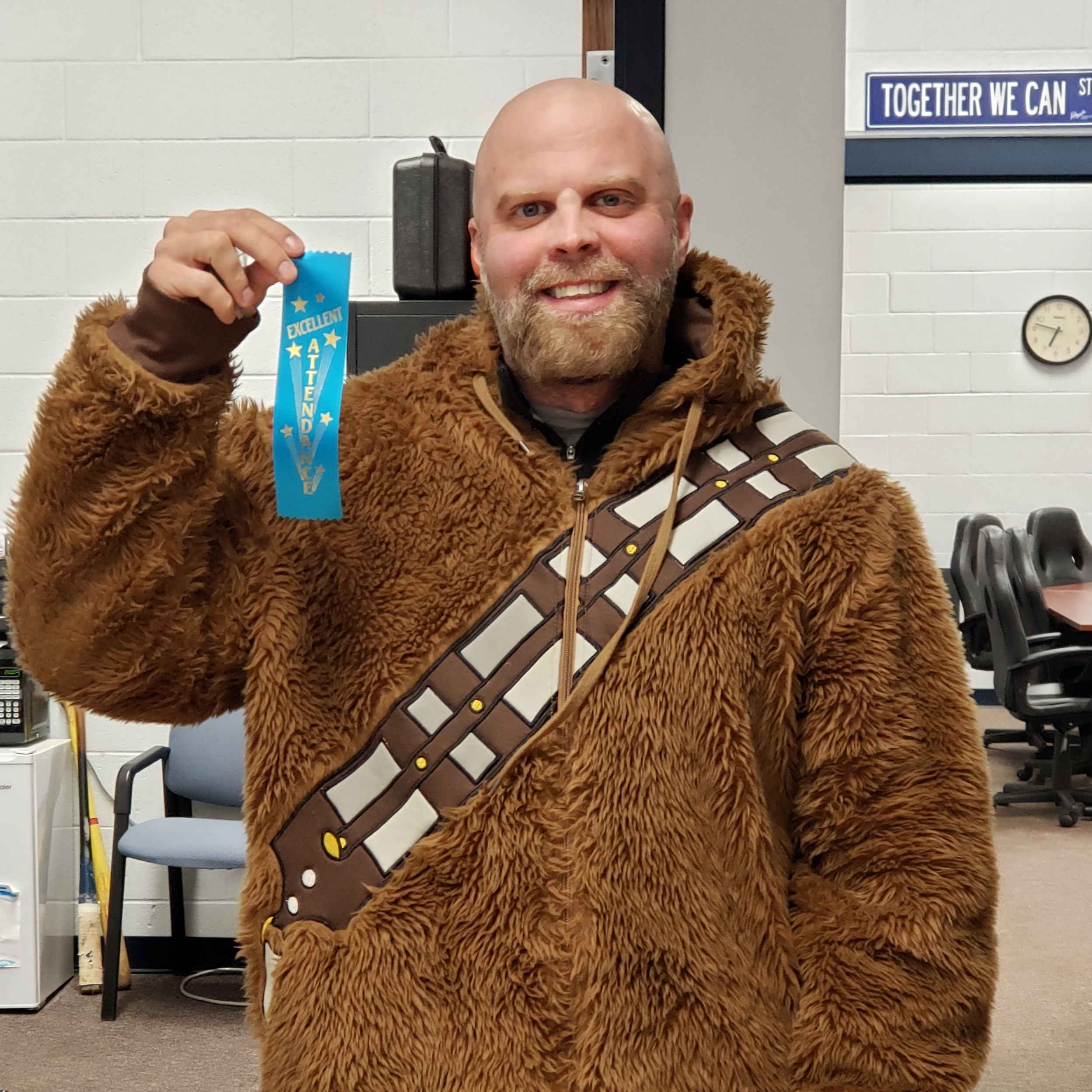 smiling male staff membery long sleeve quarter zip shirt, a staff badge , and a black lanyard