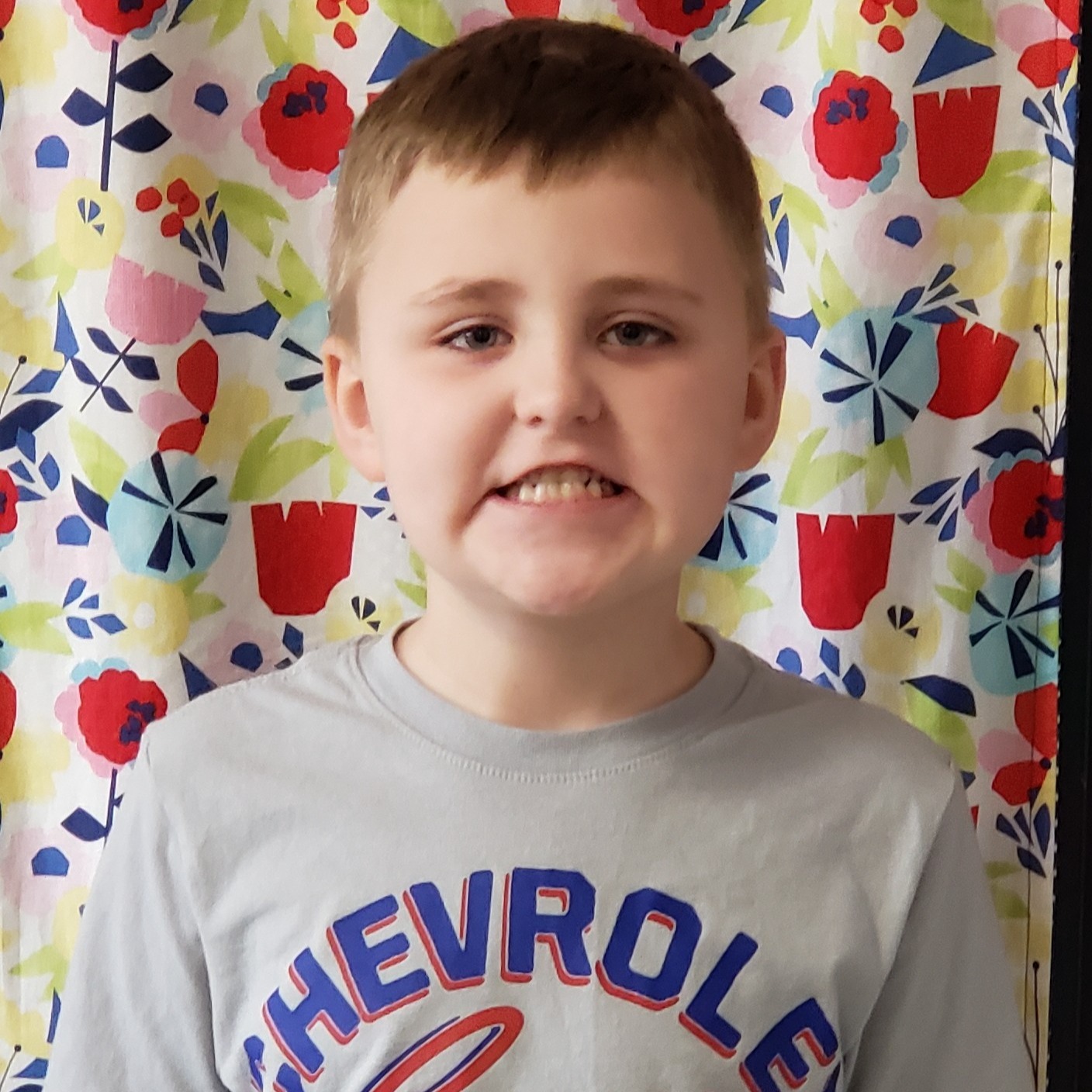 young boy with light brown hair wearing a gray t-shirt