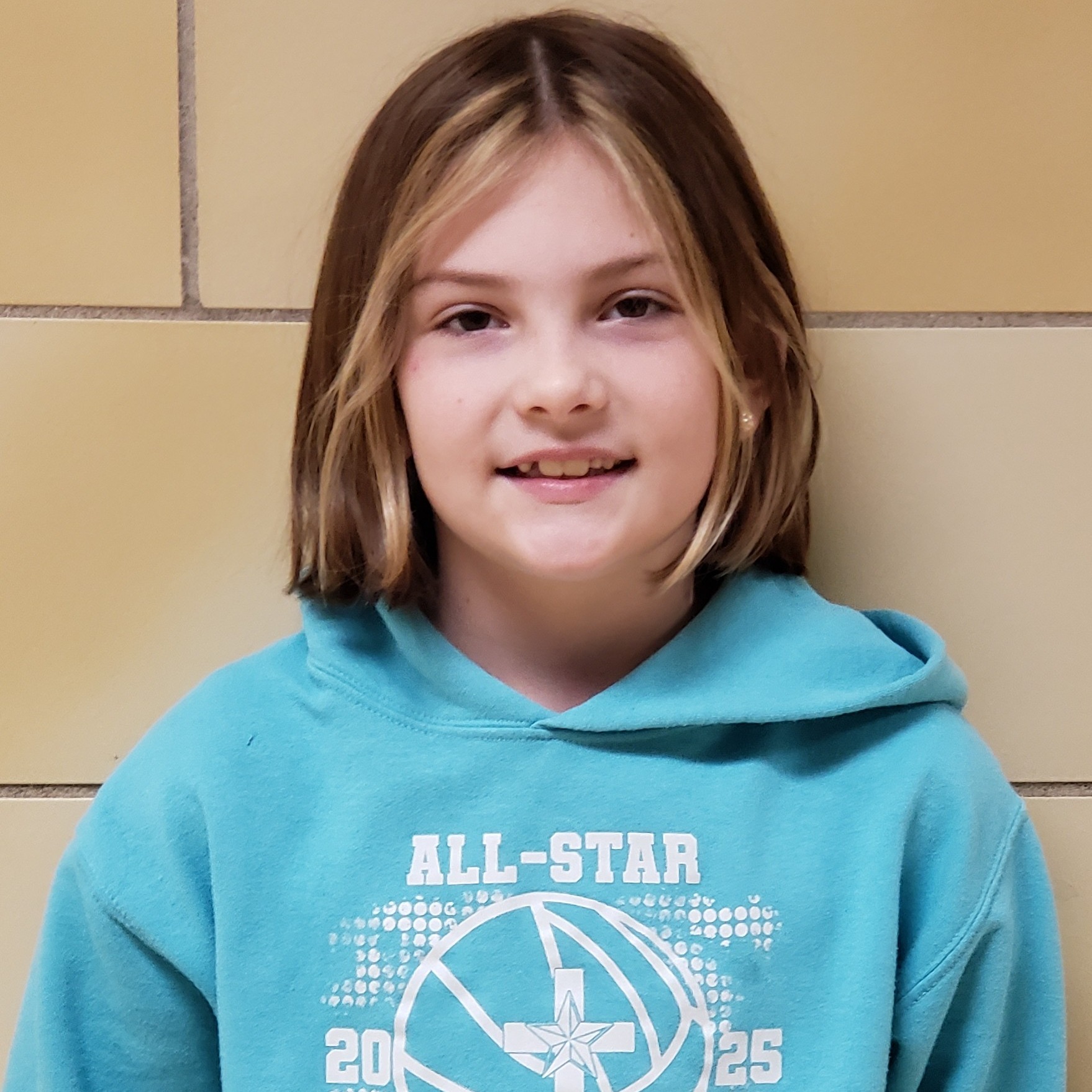 young girl with brown hair wearing a light blue hooded seatshirt