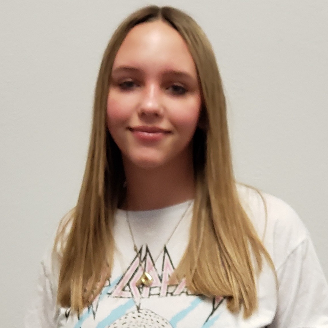 young lady with dark blonde hair wearing a white t-shirt