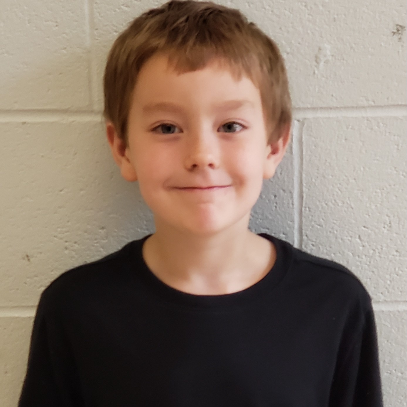 young boy with blonde hair wearing a black t-shirt