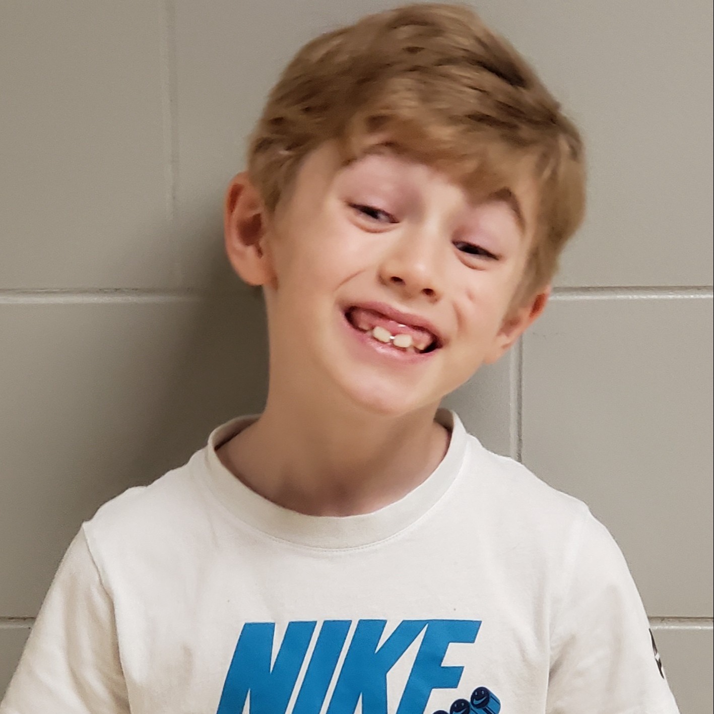 young boy with blonde hair wearing a white t-shirt