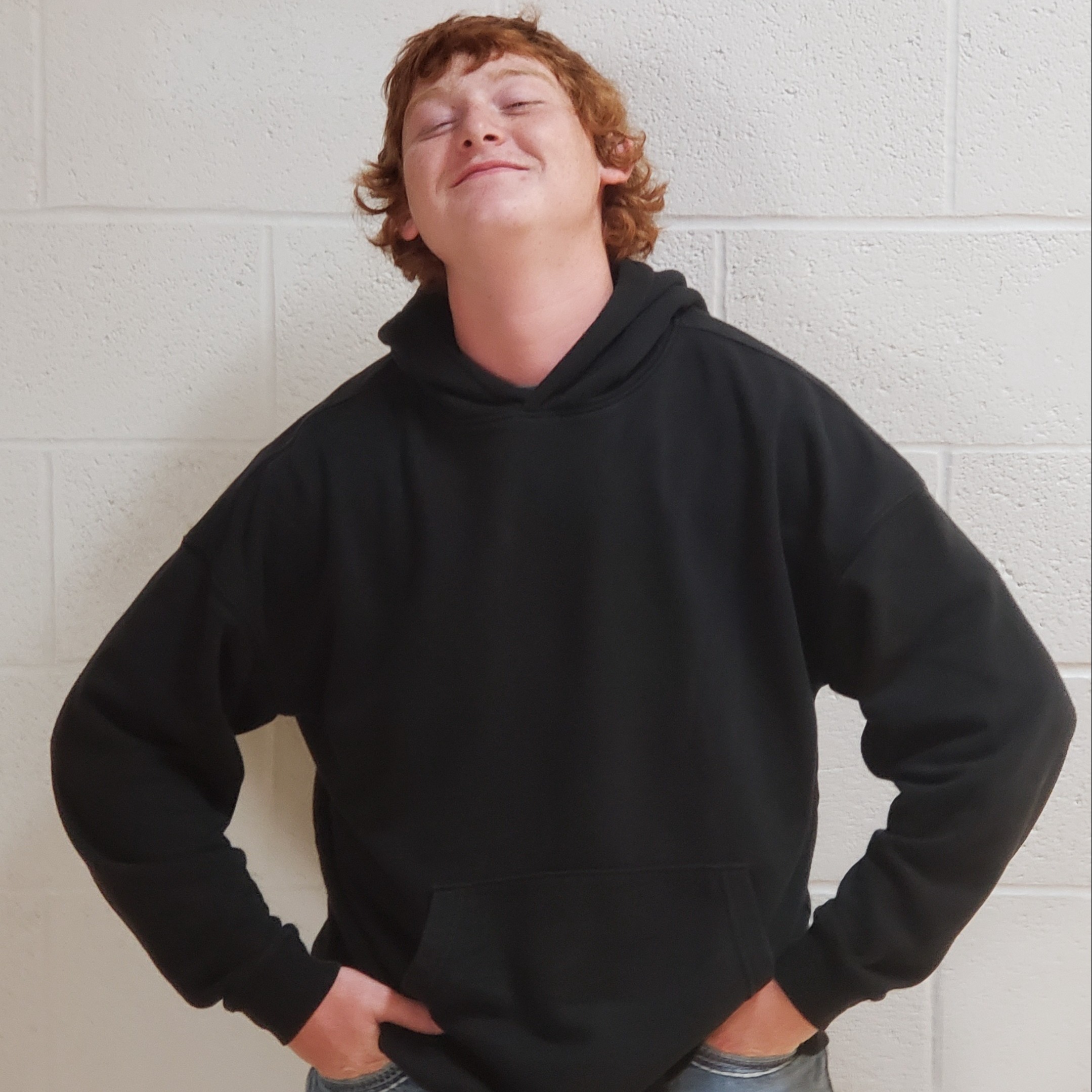 young man with red hair wearing a black hooded sweatshirt