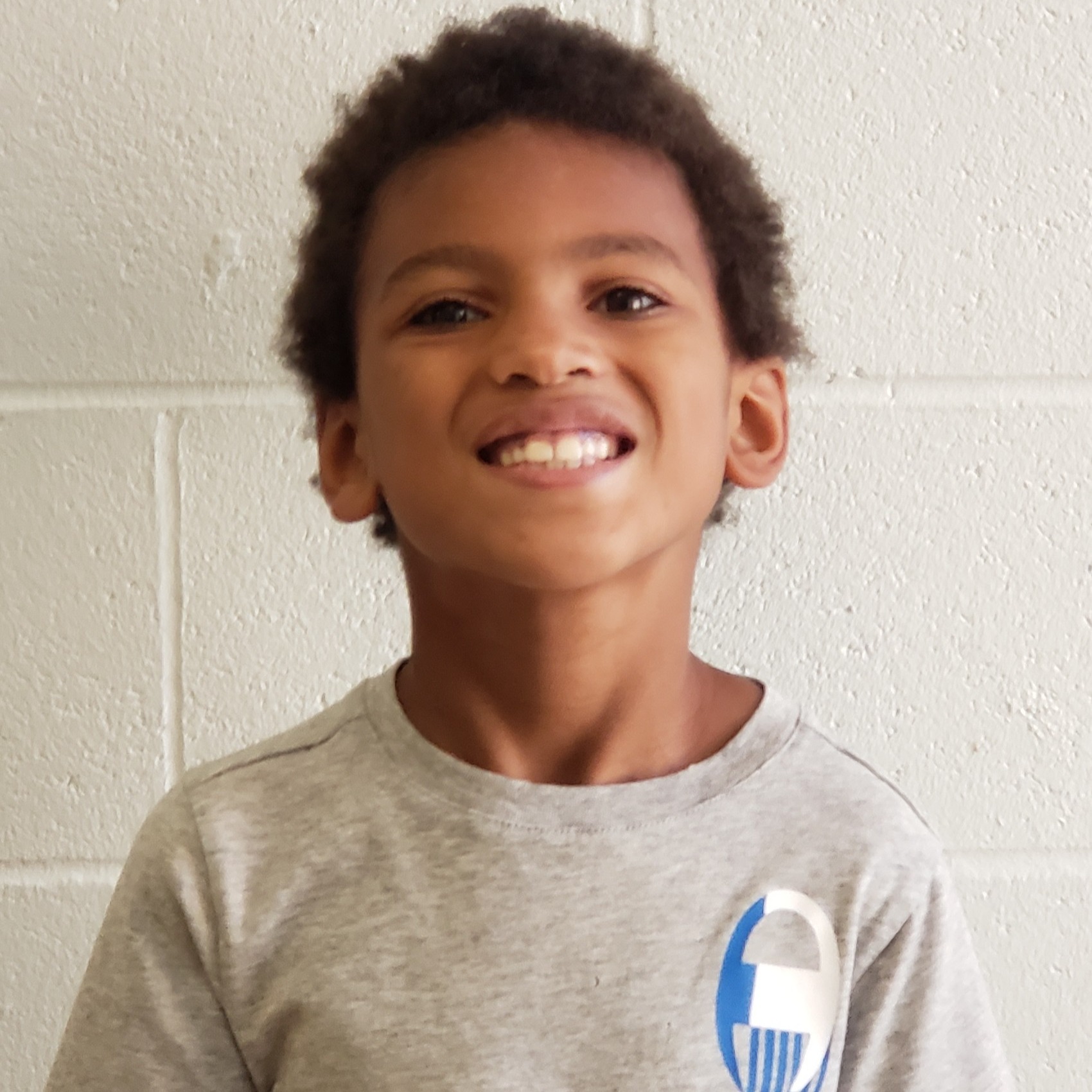 smiling African American little boy wearing a gray t-shirt