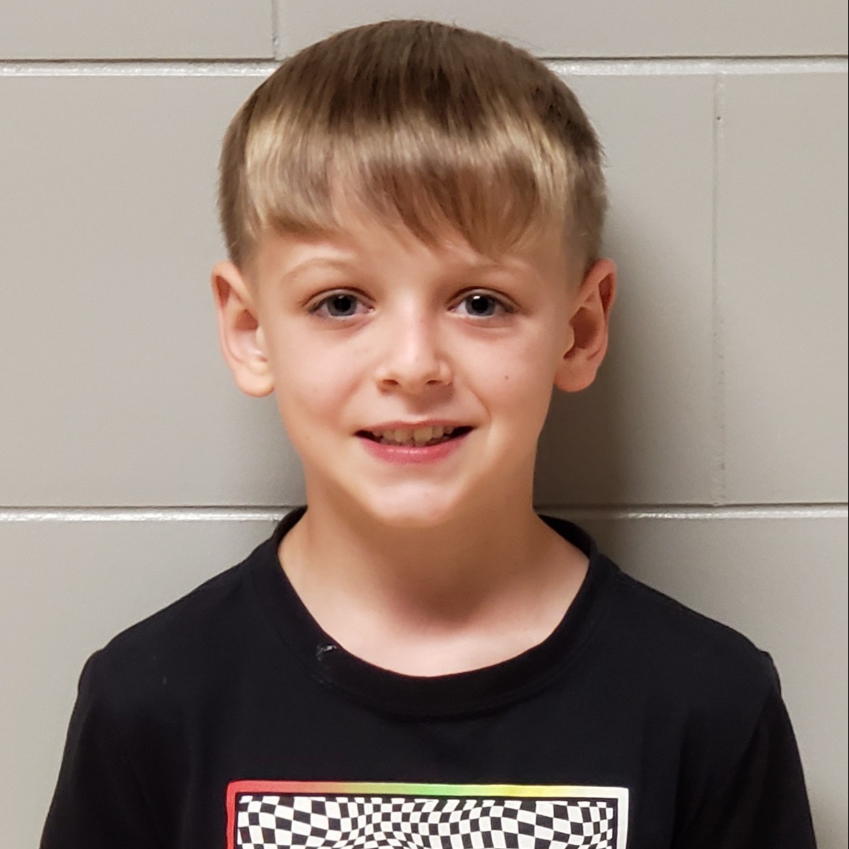 boy with blonde hair wearing a black t-shirt