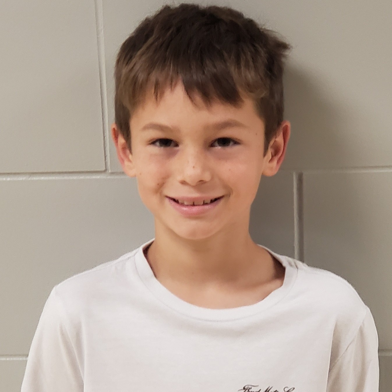 boy with brown hair wearing a white t-shirt
