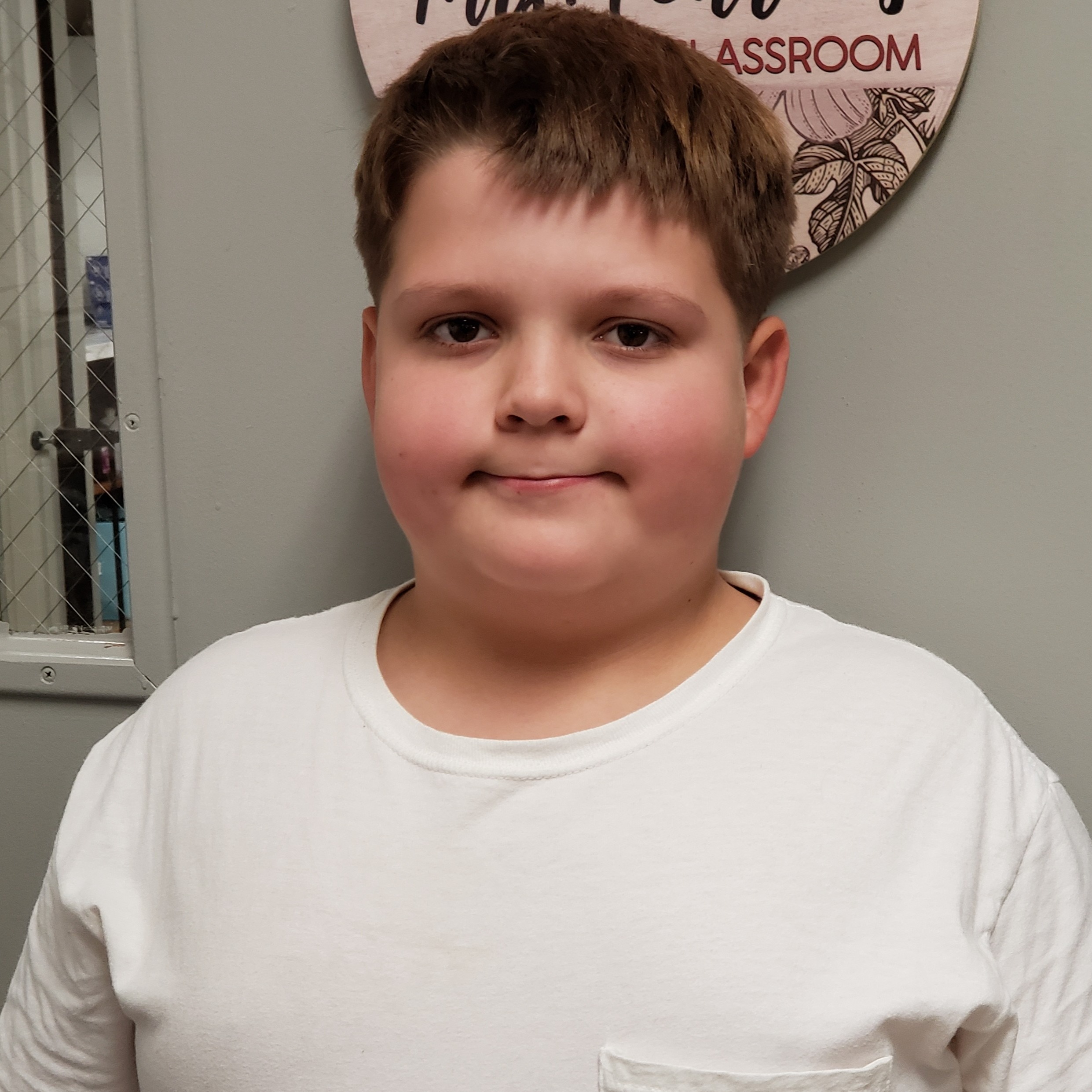 boy with dark blonde hair wearing a white t-shirt