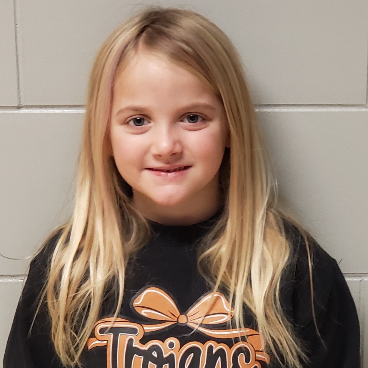 smiling girl with blonde hair wearing a black Trojans sweatshirt