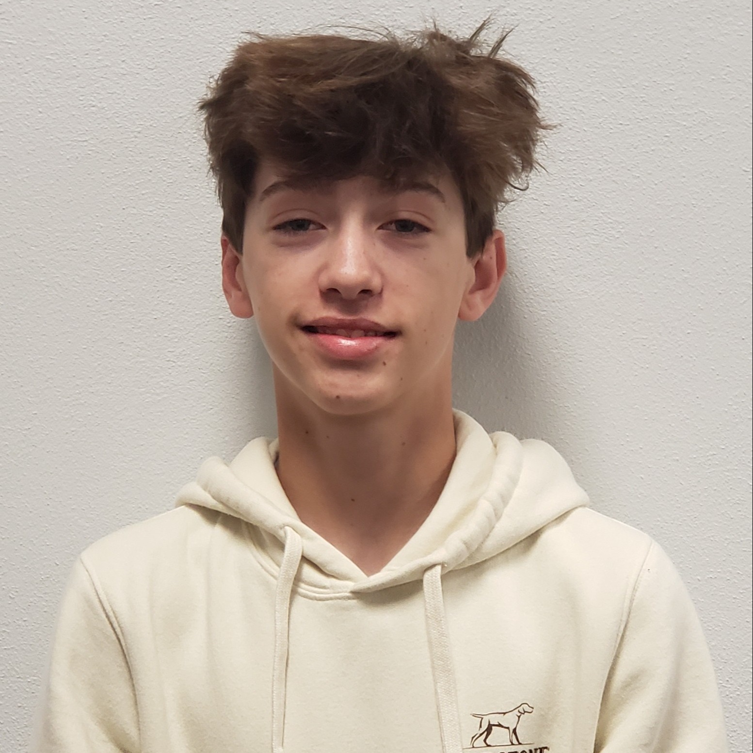 smiling young man with brown hair wearing a white hoodie