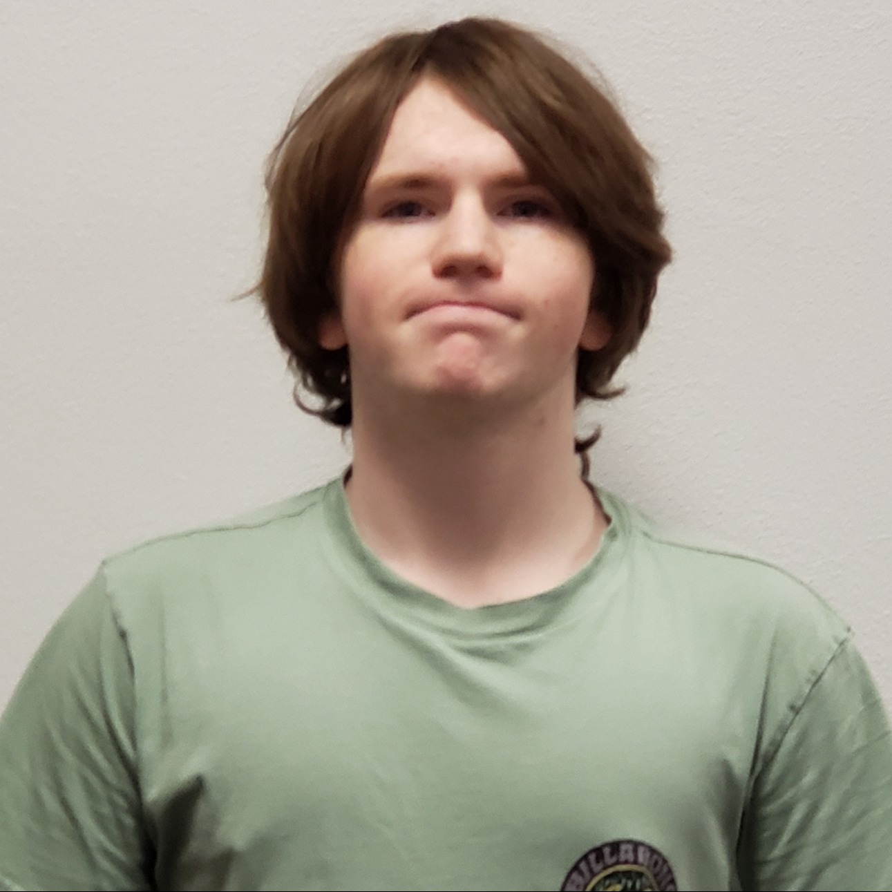 young man with reddish hair wearing a light green t-shirt