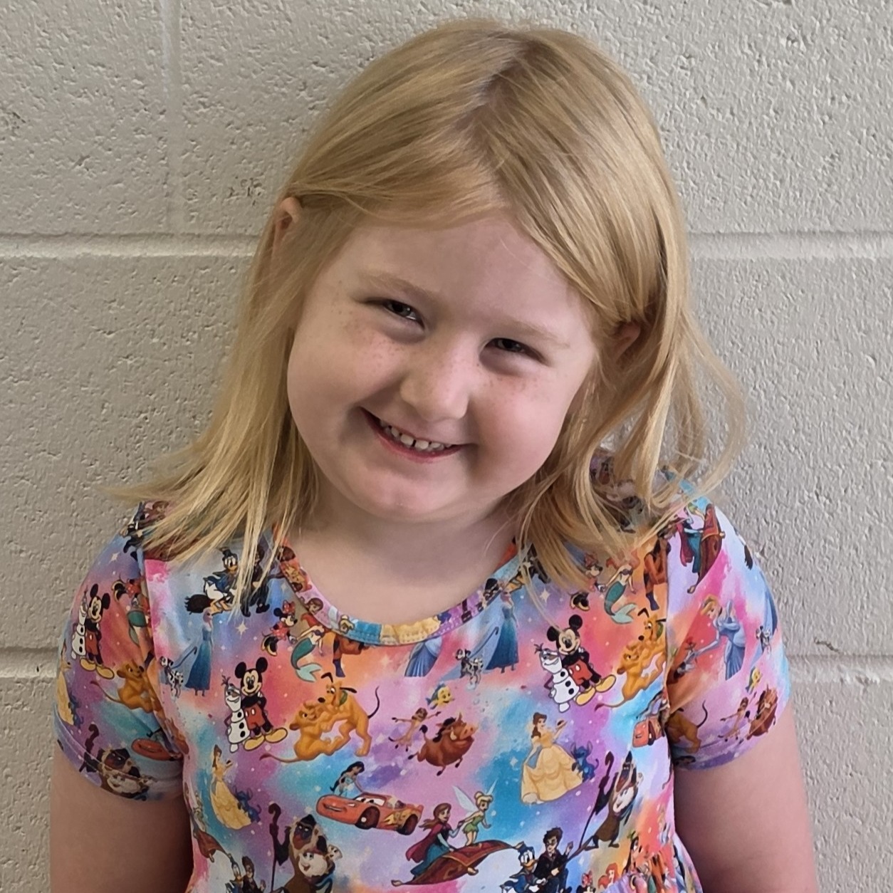 young girl with blonde hair wearing a disney princess dress