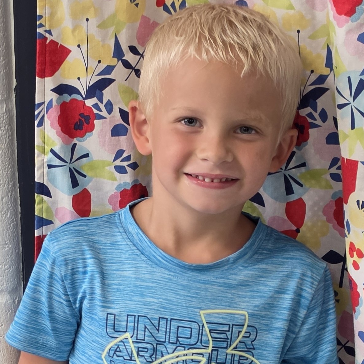 young boy with blonde hair wearing a blue t-shirt