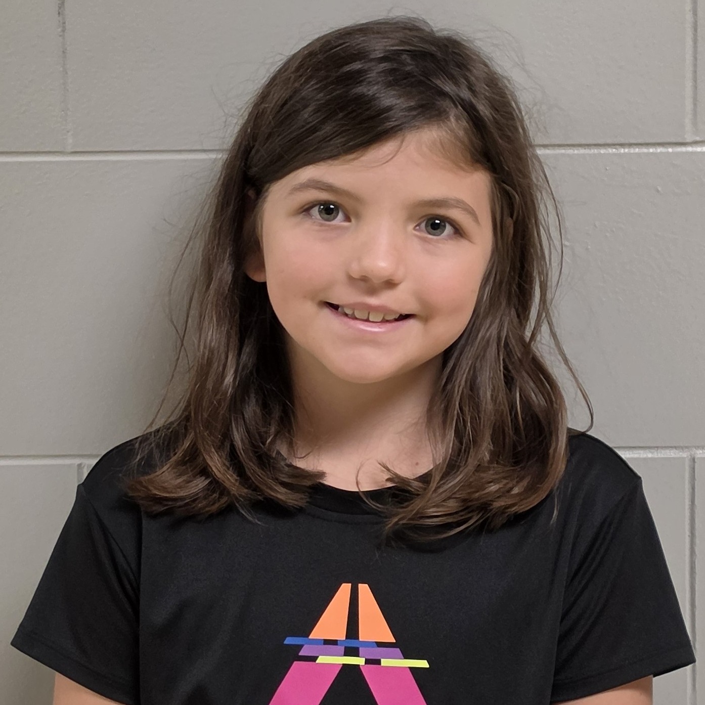 smiling girl with dark hair wearing a black t-shirt