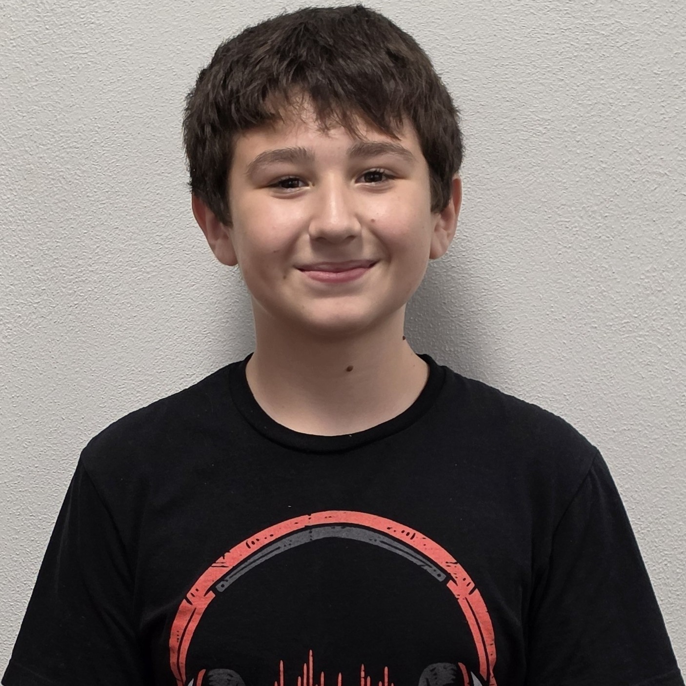 smiling boy with dark hair  wearing a black t-shirt