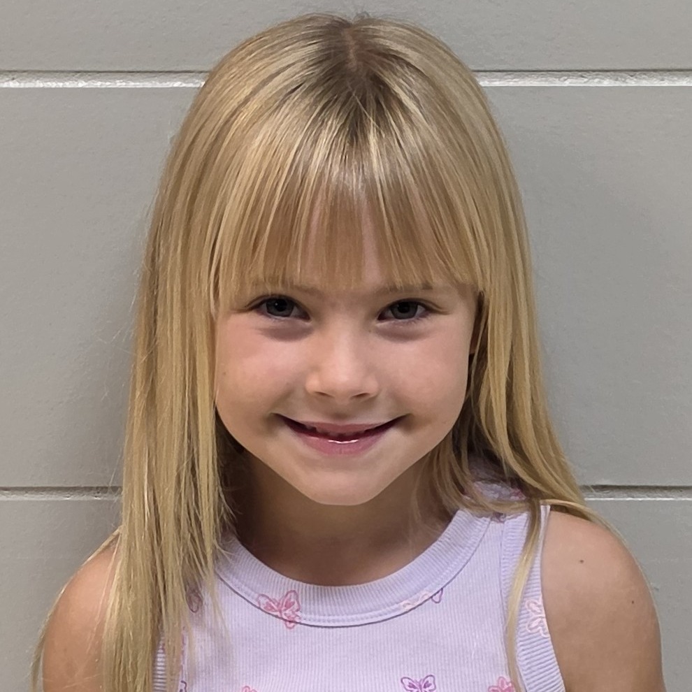 smiling girl with blonde hair wearing a pink tank top