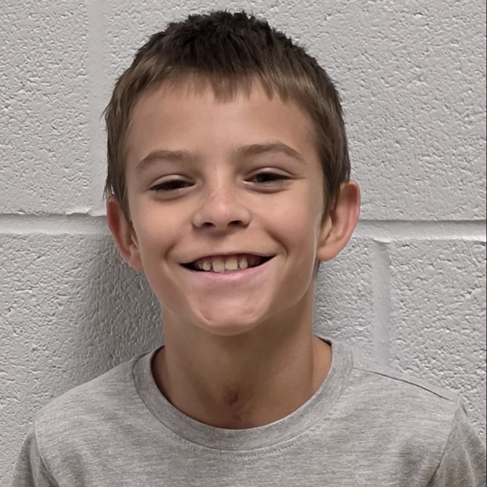 smiling boy with brown hair wearing a gray t-shirt