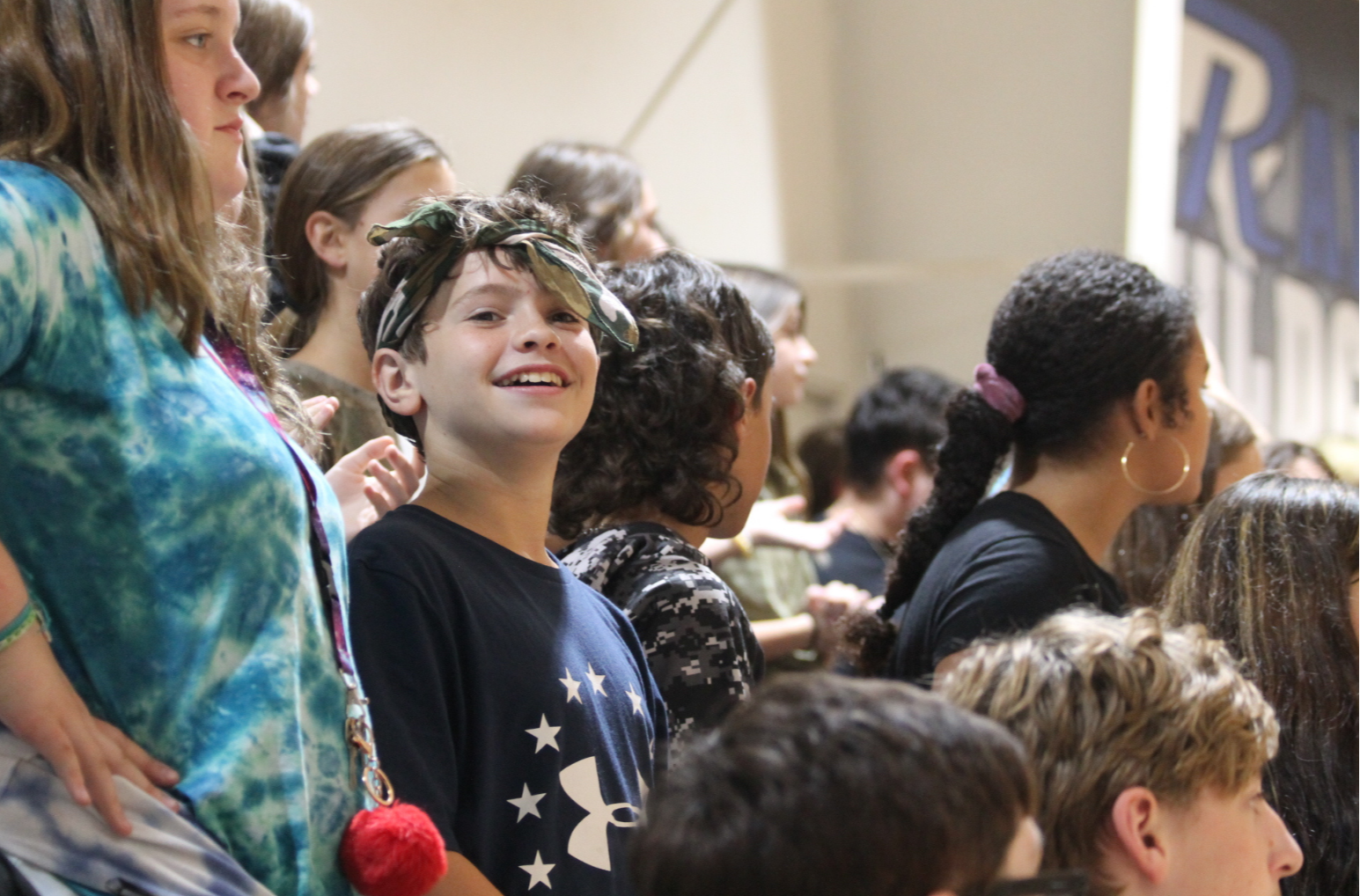 Student smiles in a crowd at a pep rally