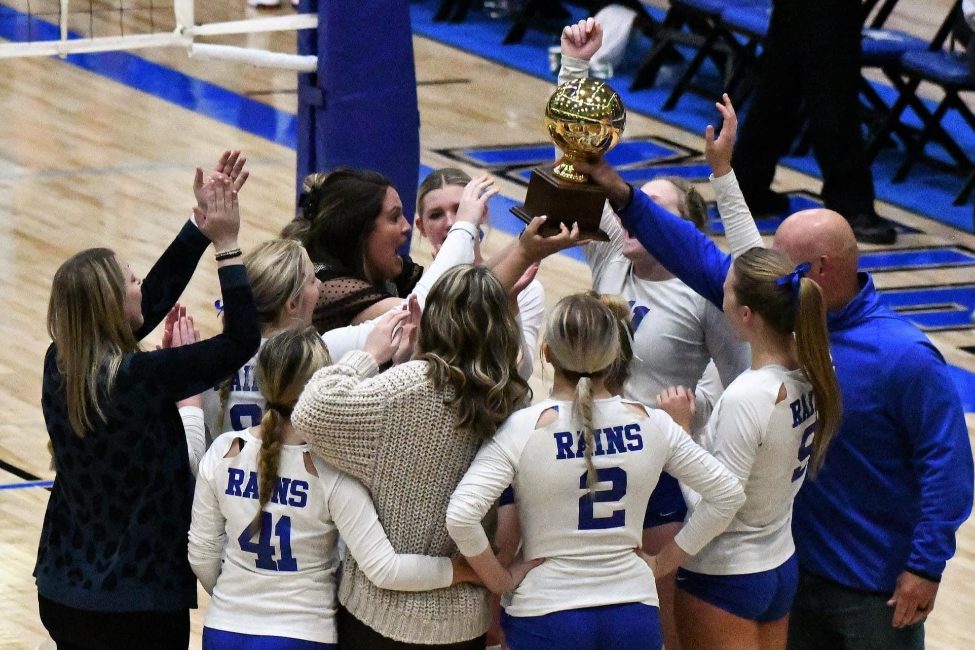 Lady Cat volleyball area champions touching trophy as a group