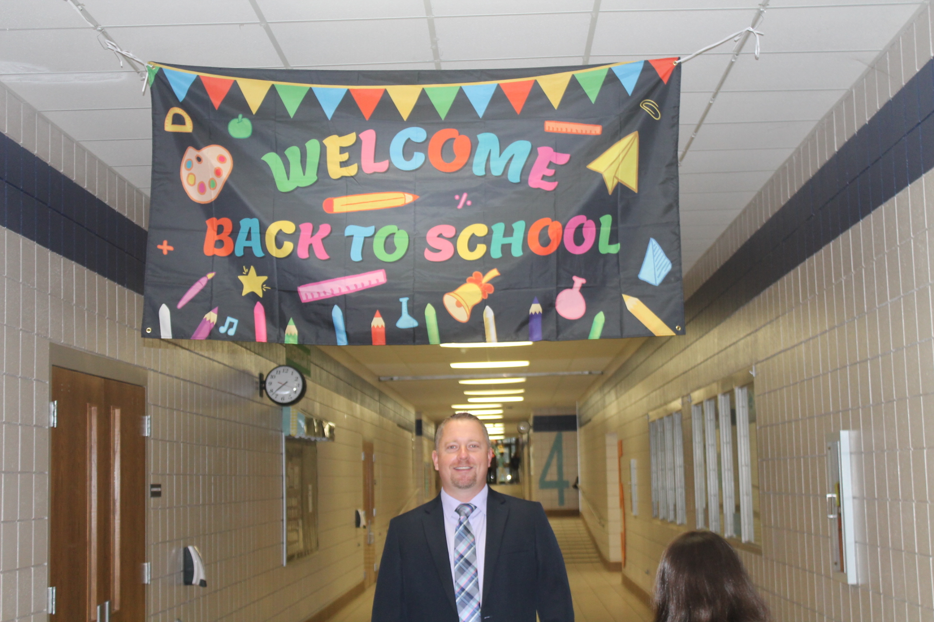 Principal Vance under the "Welcome to Rains Intermediate" sign on the first day of school