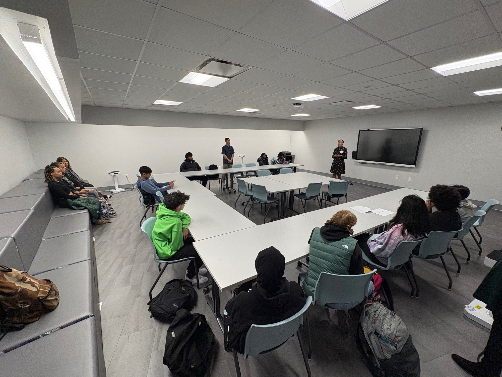 Image of the NRHS Library Multi-Purpose Room arranged in a horse-shoe pattern with students listening to a speaker