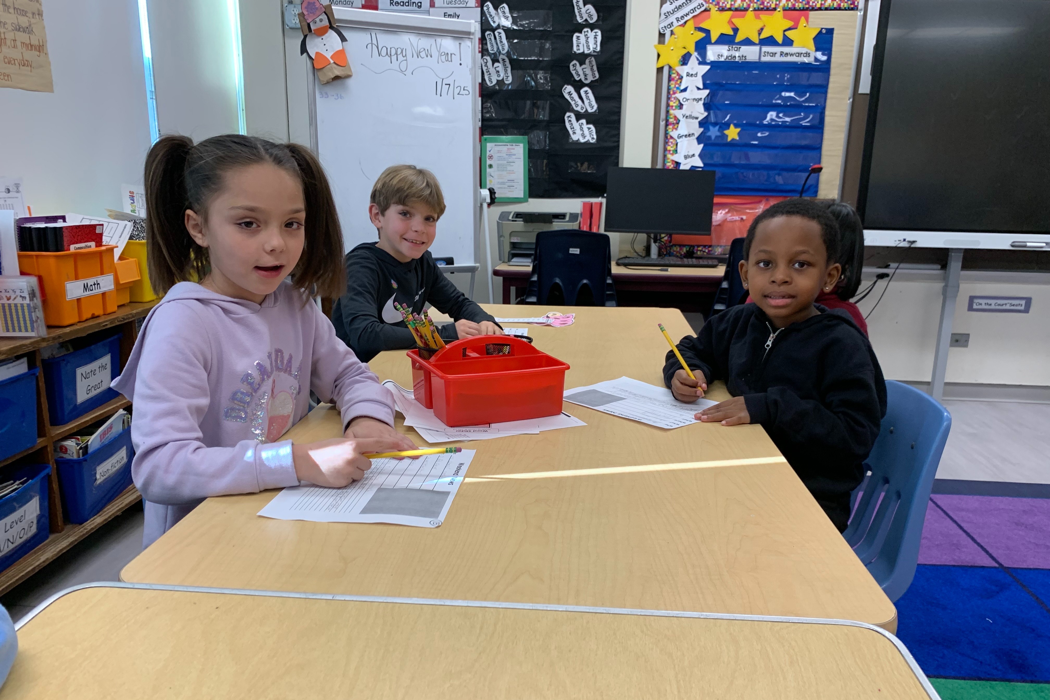 Three students collaborate at a table.