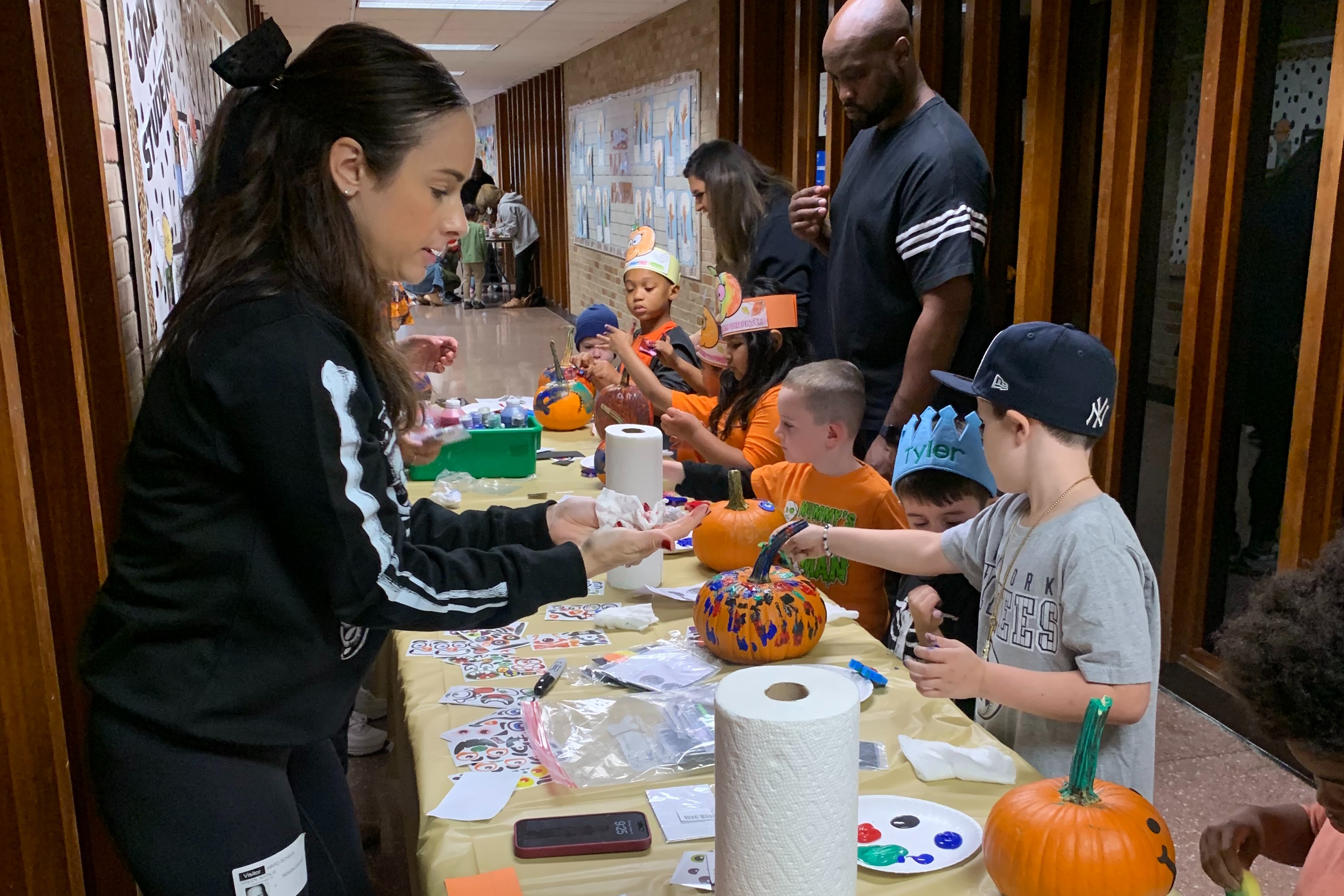 Parents assist students with decorating pumpkins.