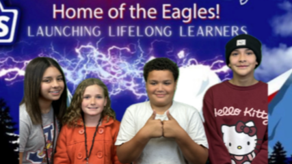 four students standing in front of an Edison school banner