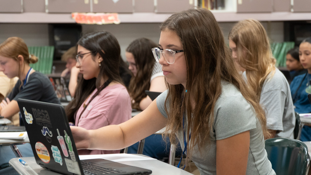 students sitting in classroom with laptops