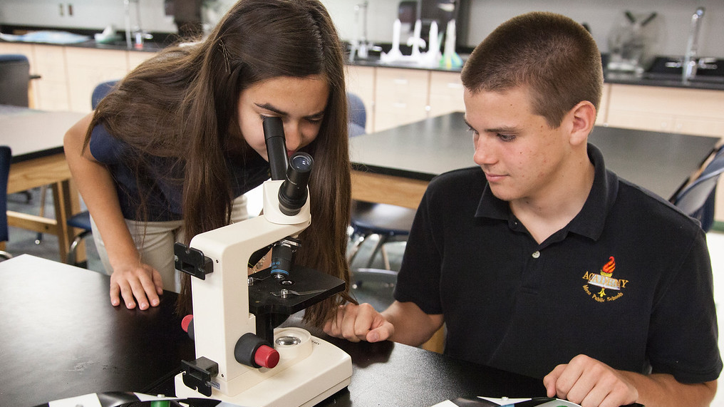 two students using a microscope
